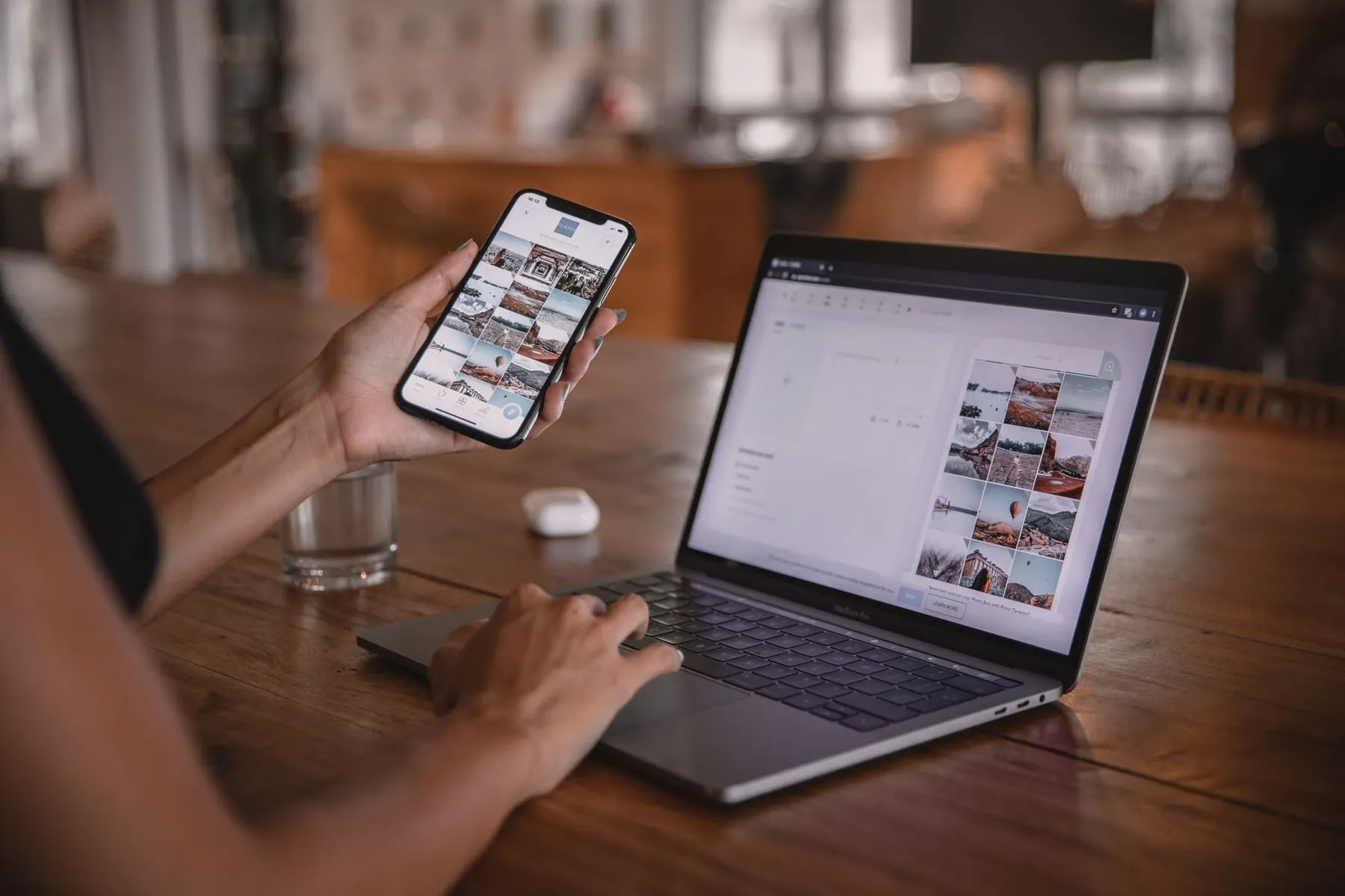 Pessoa planejando conteúdo com o celular e o notebook em uma mesa de café