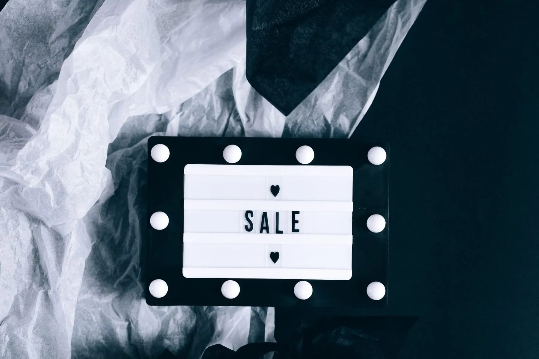 Letreiro luminoso de promoção entre sacolas de compras